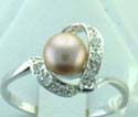 thin band ring with mini white cz holding a brown pearl